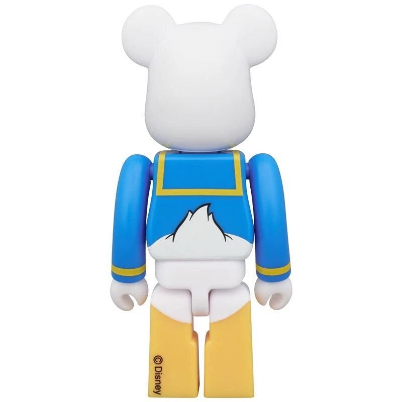 Back view of Bearbrick figure as Donald Duck with white body, blue sailor shirt, and yellow legs.