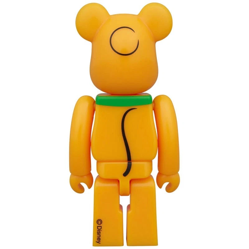 Rear view of Bearbrick figure designed as Pluto with orange body, green collar, and black tail detail.
