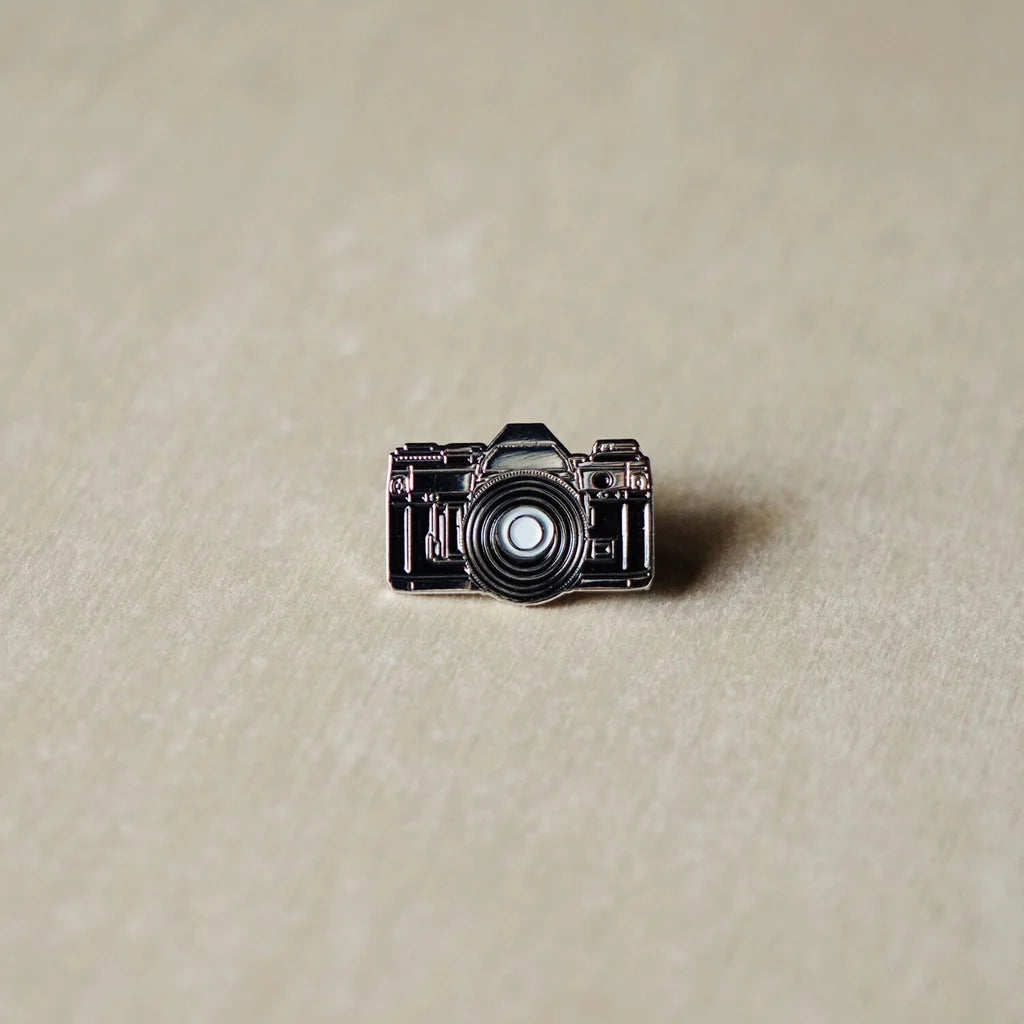 35mm enamel pin with retro camera design on white background