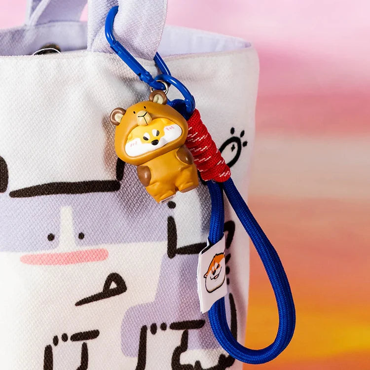 Puppy Crossing keychain figure Shiba in a bear costume with blue lanyard attached to a bag