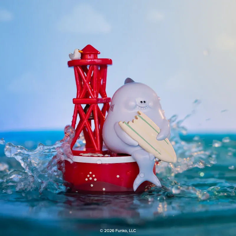 Blonks shark figure sitting on buoy with surfboard