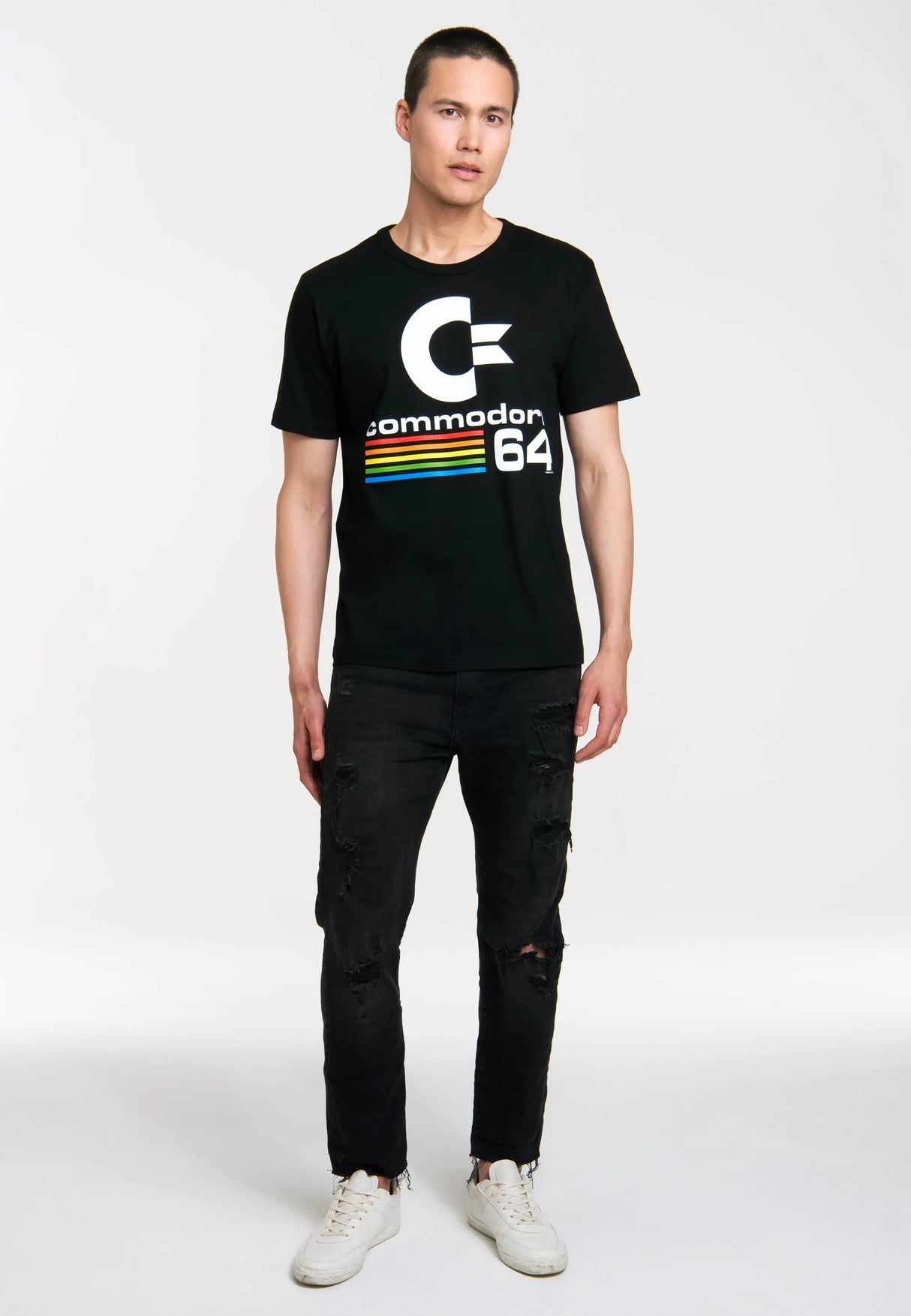 Full-body shot of man in Commodore 64 C64 logo t-shirt and black jeans