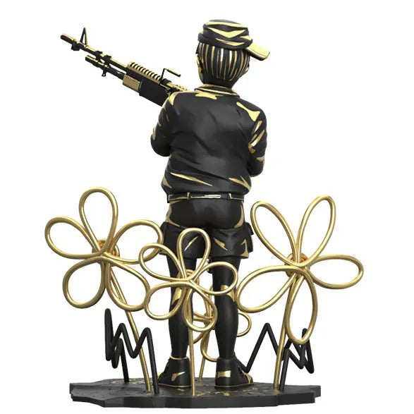 Rear view of Banksy’s Crayon Shooter collectible figure surrounded by golden doodle flowers