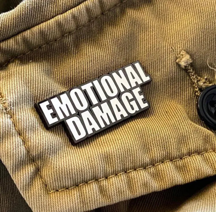 Emotional Damage enamel pin displayed on a khaki jacket