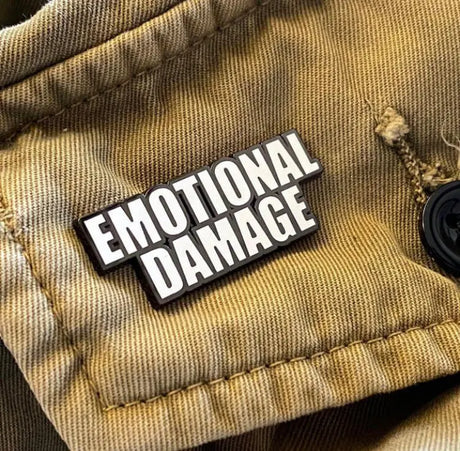 Emotional Damage enamel pin displayed on a khaki jacket