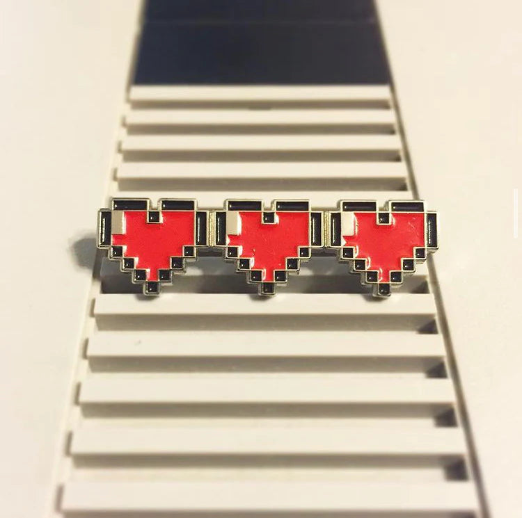 Yesterdays Full Health enamel pin photographed on retro gaming console surface