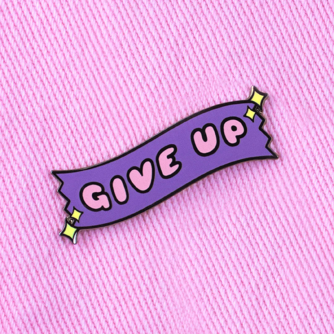 give up enamel pin attached to pink fabric aesthetic enamel pin