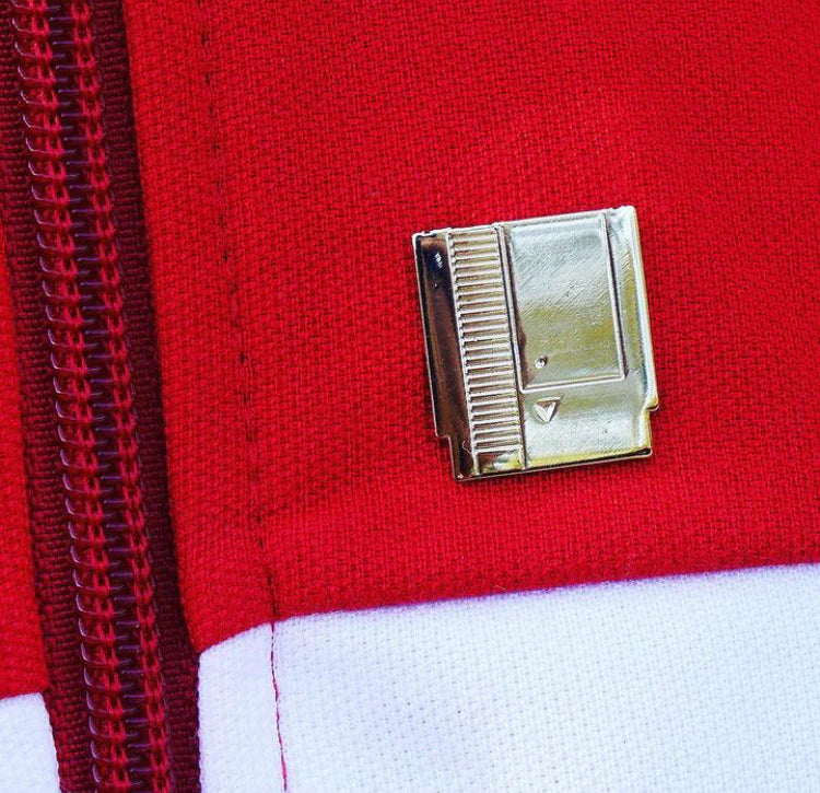 Mini collectible pin designed like a vintage gold cartridge