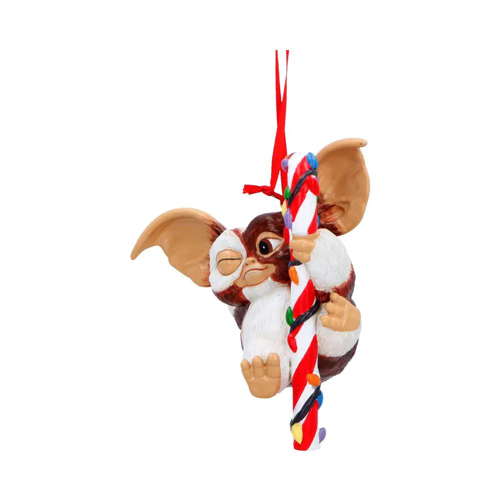 Side view of Gizmo clinging to a festive candy cane ornament