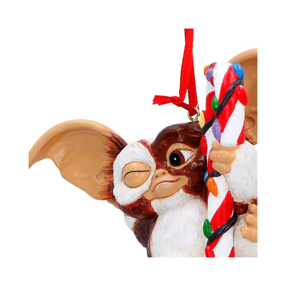 Close-up of Gizmo holding a candy cane wrapped in colourful fairy lights