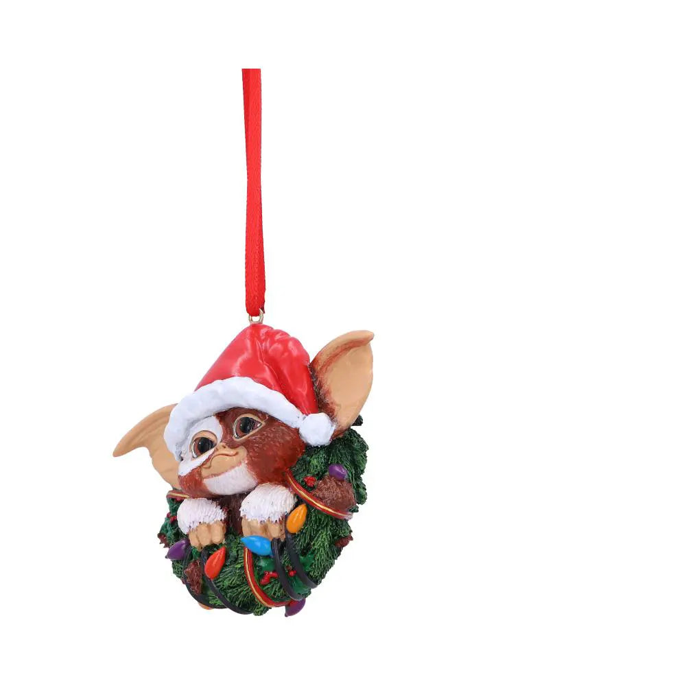 Side view of Gizmo peeking from a Christmas wreath