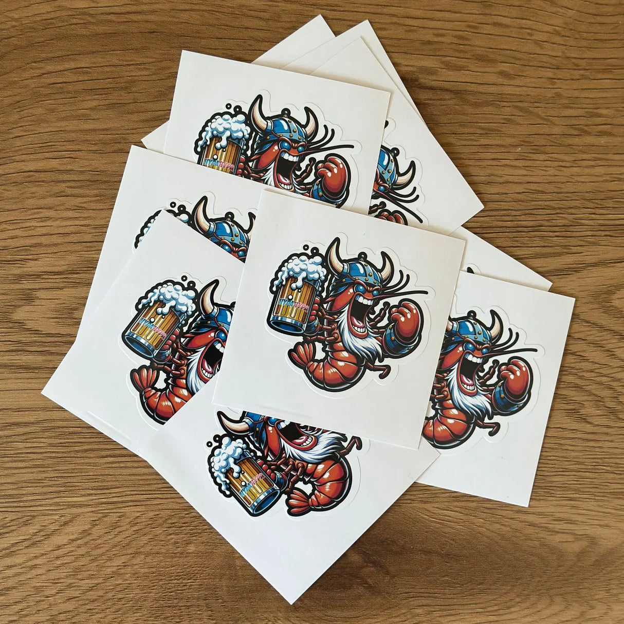 Pile of HypaHypa Hyped Up Viking Shrimp stickers spread out on a wooden surface.