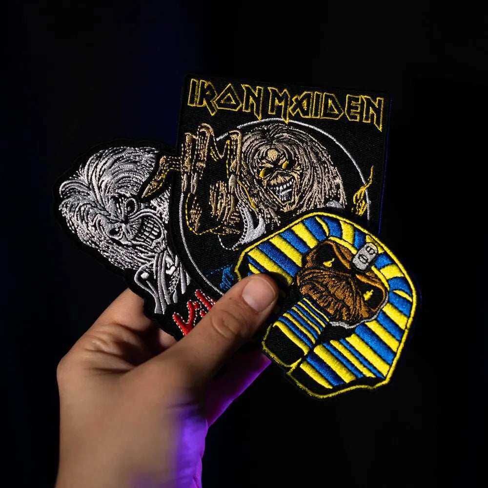 Hand holding Iron Maiden patch set with Eddie designs
