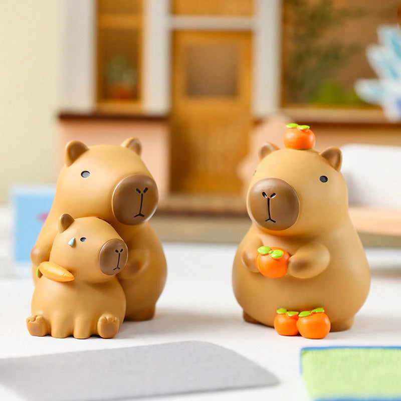 Capybara figures from the Little Bean series holding persimmons and standing side by side.