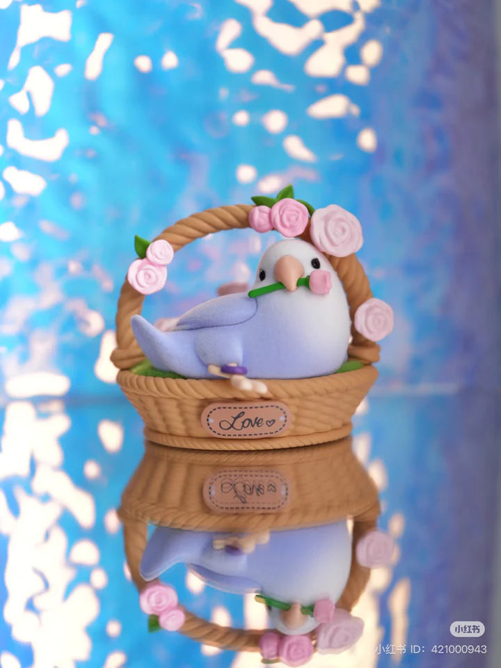 Lovebird Social Birdie vinyl figure in a basket decorated with roses