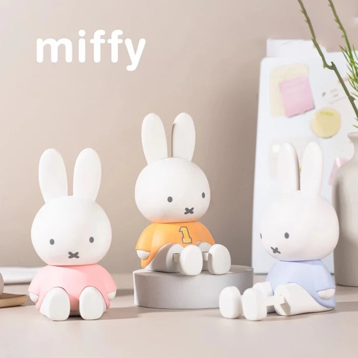 Pink, orange, and lavender Miffy phone stand collectibles displayed together