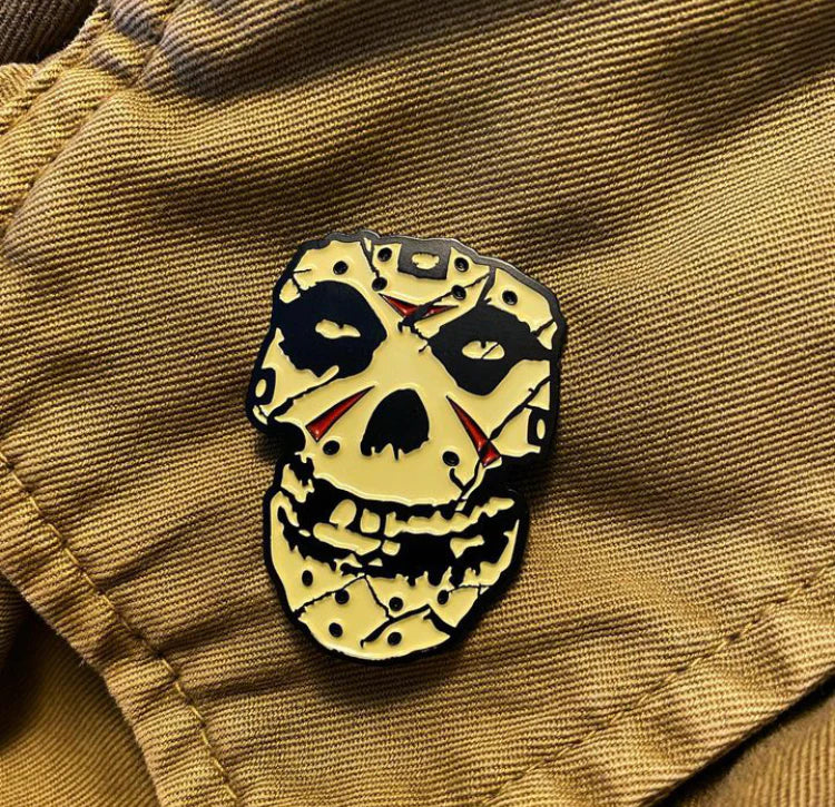 Official Misfits horror-themed lapel pin featuring skull design with black and red details