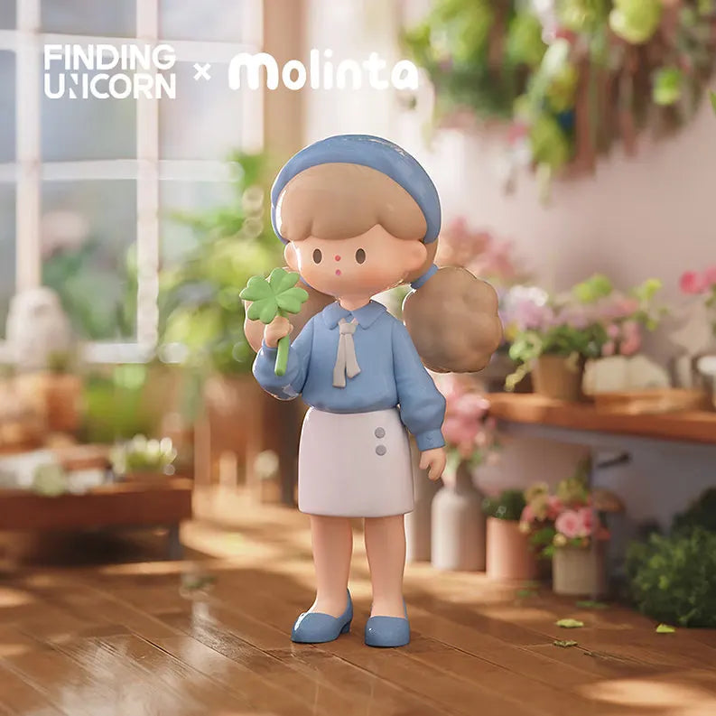 Molinta girl figurine in blue outfit holding a four-leaf clover surrounded by flowers.
