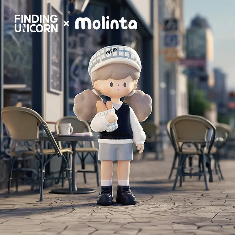 Molinta vinyl figure in school-style outfit with bread standing near a city café.