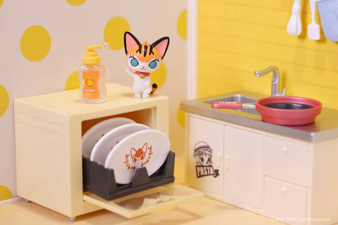 Cat figure standing on top of dish rack with detergent bottle, beside sink and frying pan