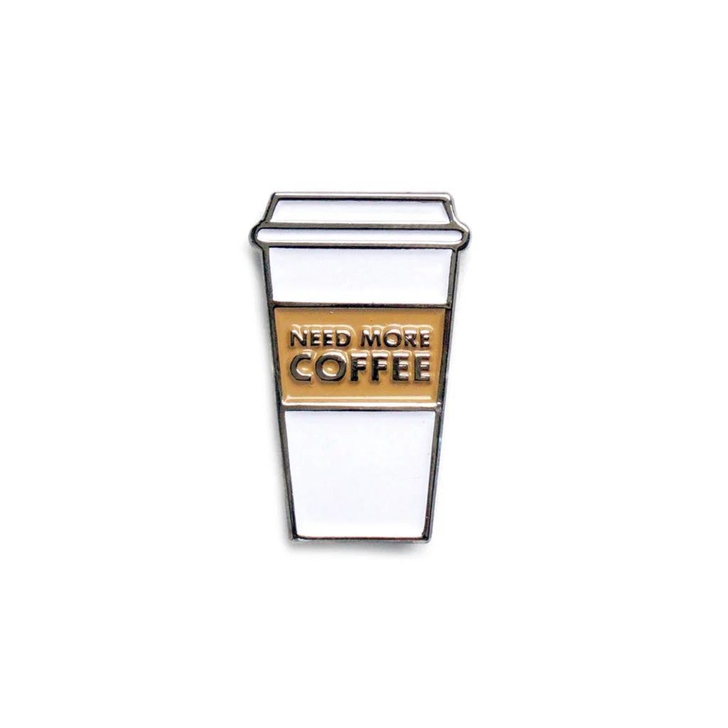 White enamel coffee cup pin with "NEED MORE COFFEE" text in gold.