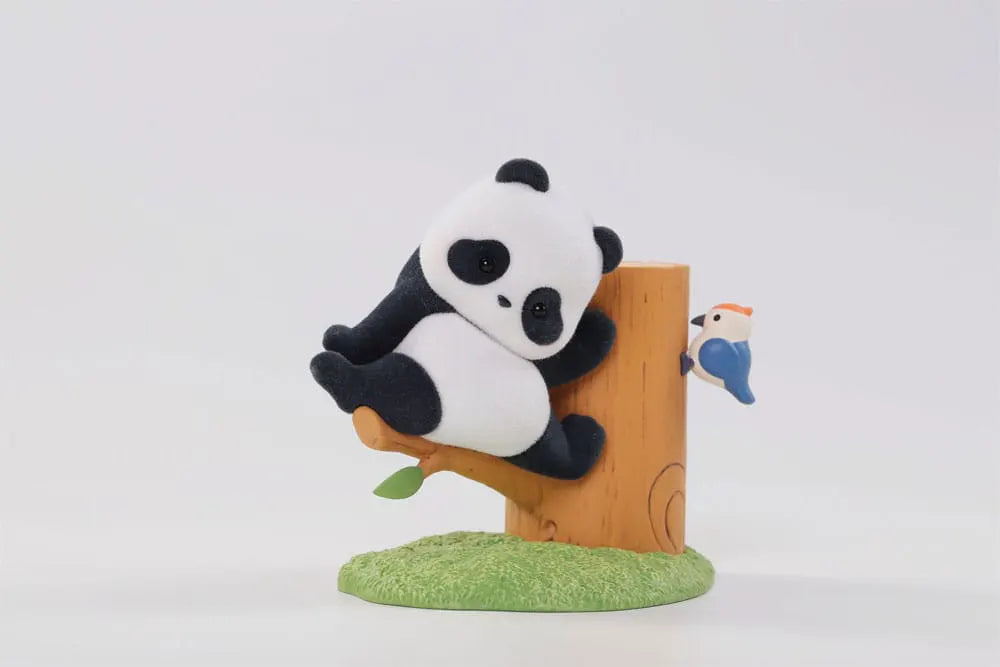 Flocked panda vinyl figure hugging a tree with a bluebird on the trunk