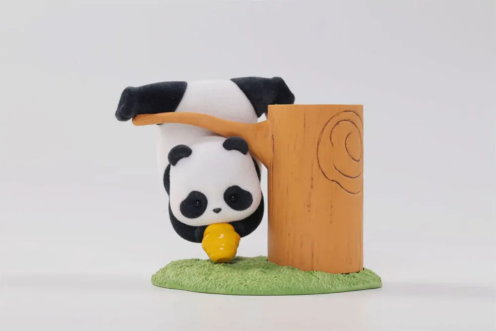 Upside-down panda hanging from a branch with a honey pot