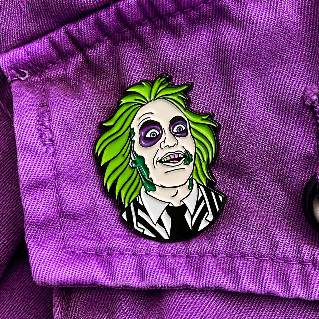 Beetlejuice enamel pin attached to a purple jacket close-up