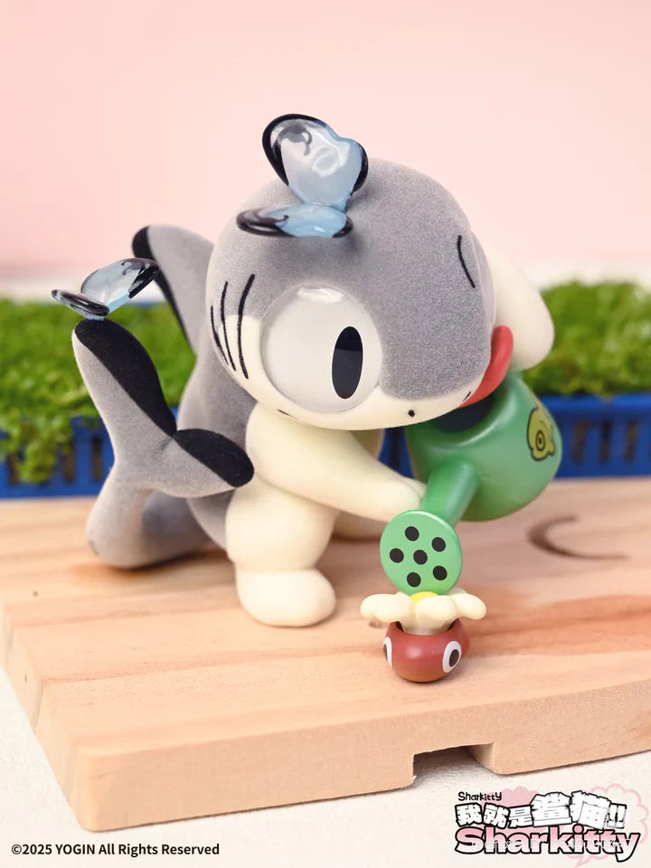 Sharkitty blindbox figure watering a plant with fish-themed watering can
