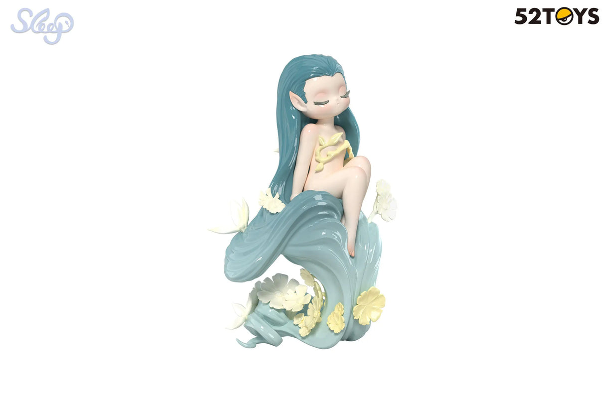 Dreamland Elves figure with aqua blue hair and cream floral accents, seated peacefully.