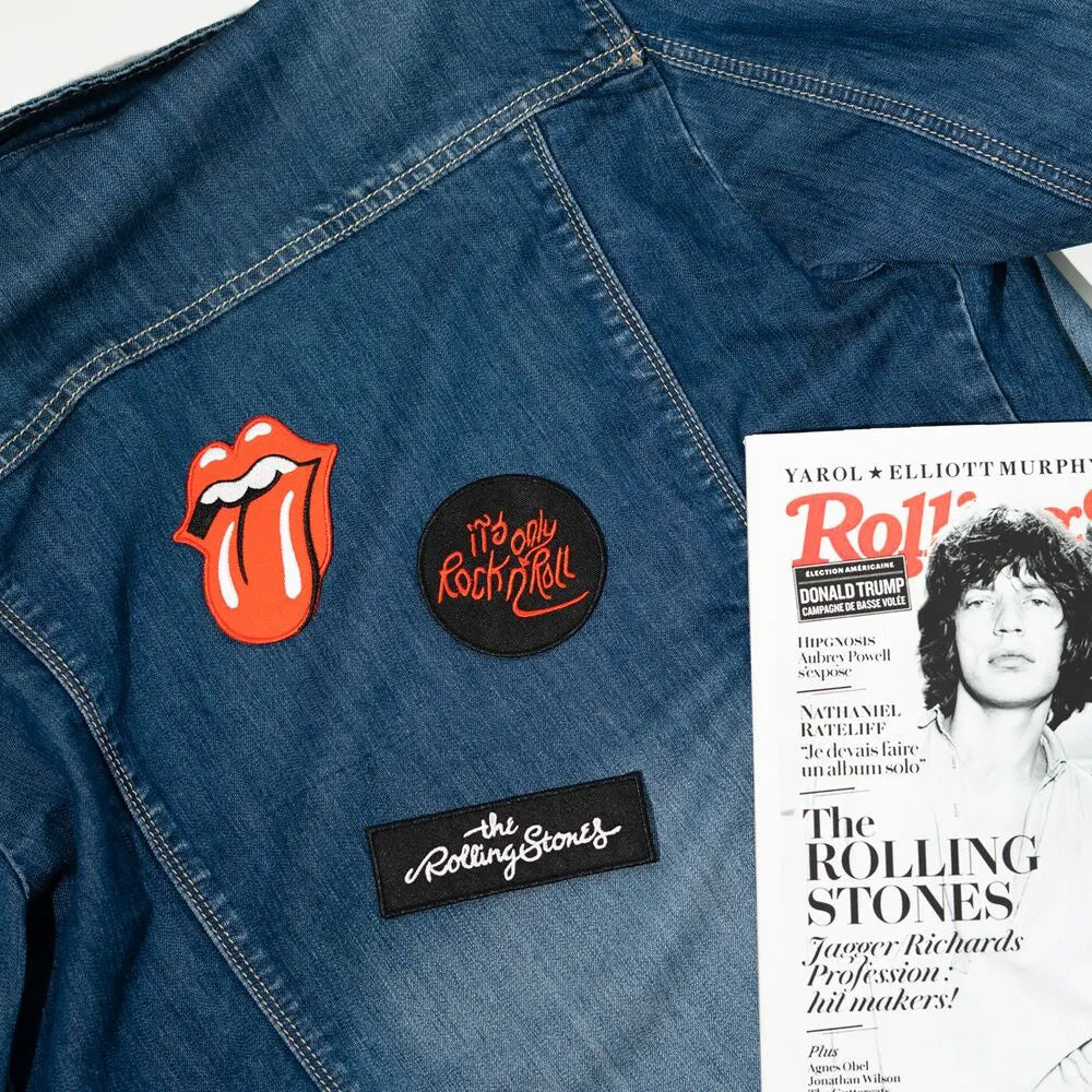 Denim jacket with Rolling Stones patches, including tongue logo, circular red text patch, and band logo.