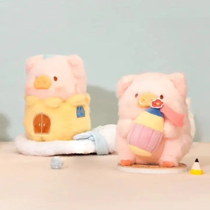 LuLu The Piggy plush holding a colorful cupcake beside a miniature plush house