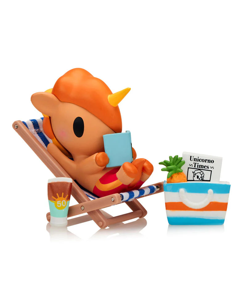 Fun in the Sun Unicorno figure relaxing on a striped beach chair with tote bag and sunscreen