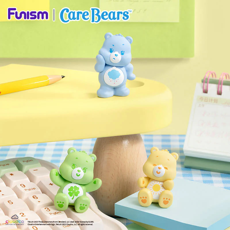 Care Bears Little Things Cubby Face Series figures displayed on a colorful desktop with Grumpy Bear, Good Luck Bear and Funshine Bear