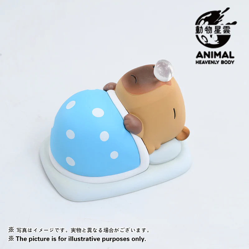Capybara vinyl figure tucked under a blue polka-dot blanket from Capybara Series 2 blind box.