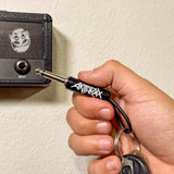 Anthrax guitar plug keychain with keys on wooden surface