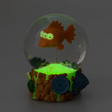 Glow-in-the-dark Blinky snow globe showing illuminated radioactive effects and glowing three-eyed fish from The Simpsons