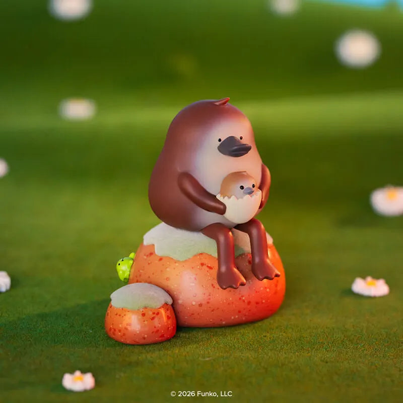 Blonks platypus figure holding baby sitting on rock