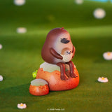 Blonks platypus figure holding baby sitting on rock