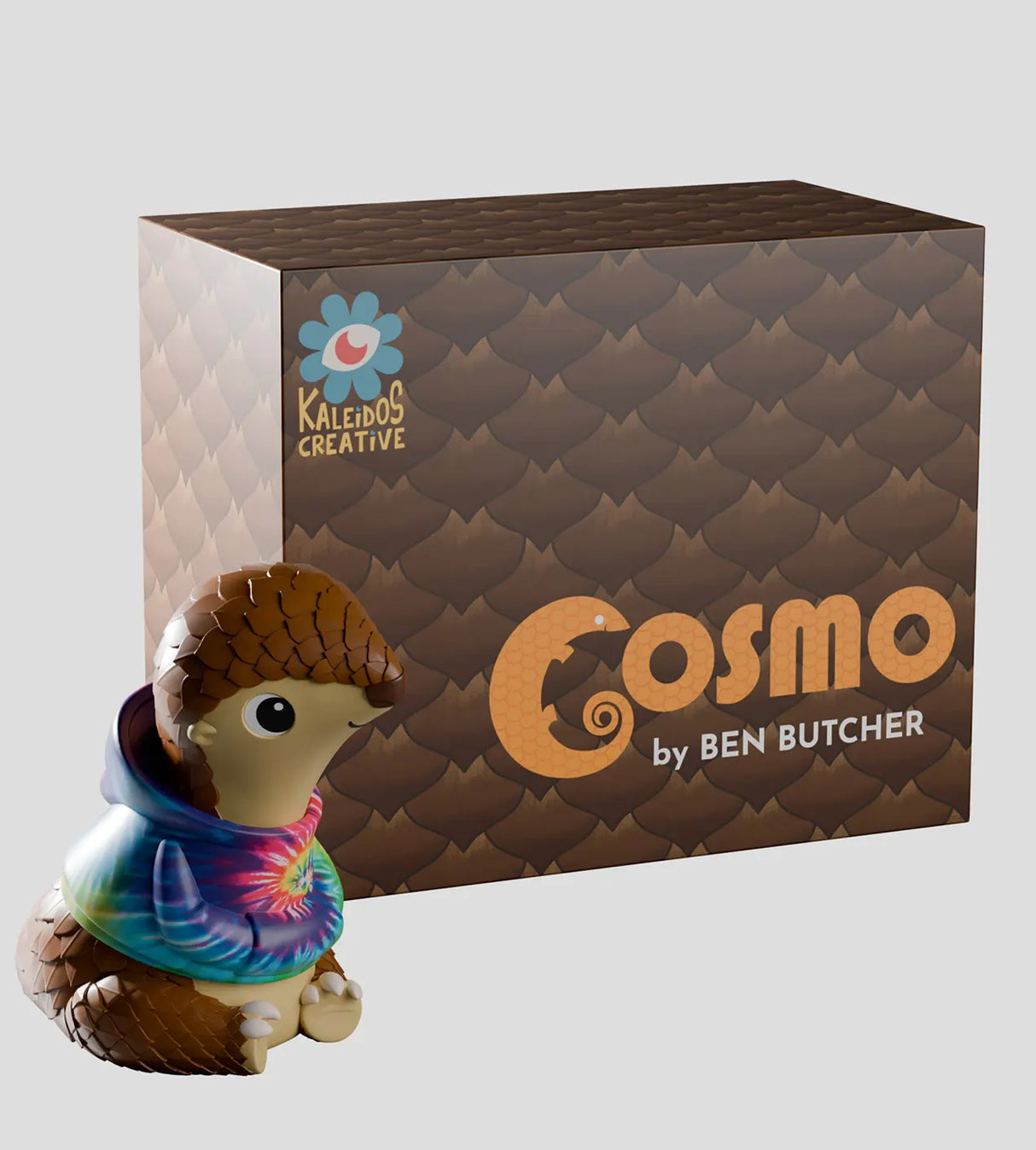 Cosmo art vinyl figure displayed next to Kaleidos Creative packaging box