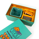 Top view of Dumpster Fire Trash Stash ceramic figure packaging contents