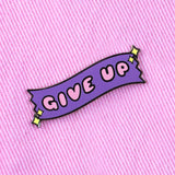 give up enamel pin attached to pink fabric aesthetic enamel pin