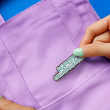 KPop Demon Hunters logo pin worn on purple fabric
