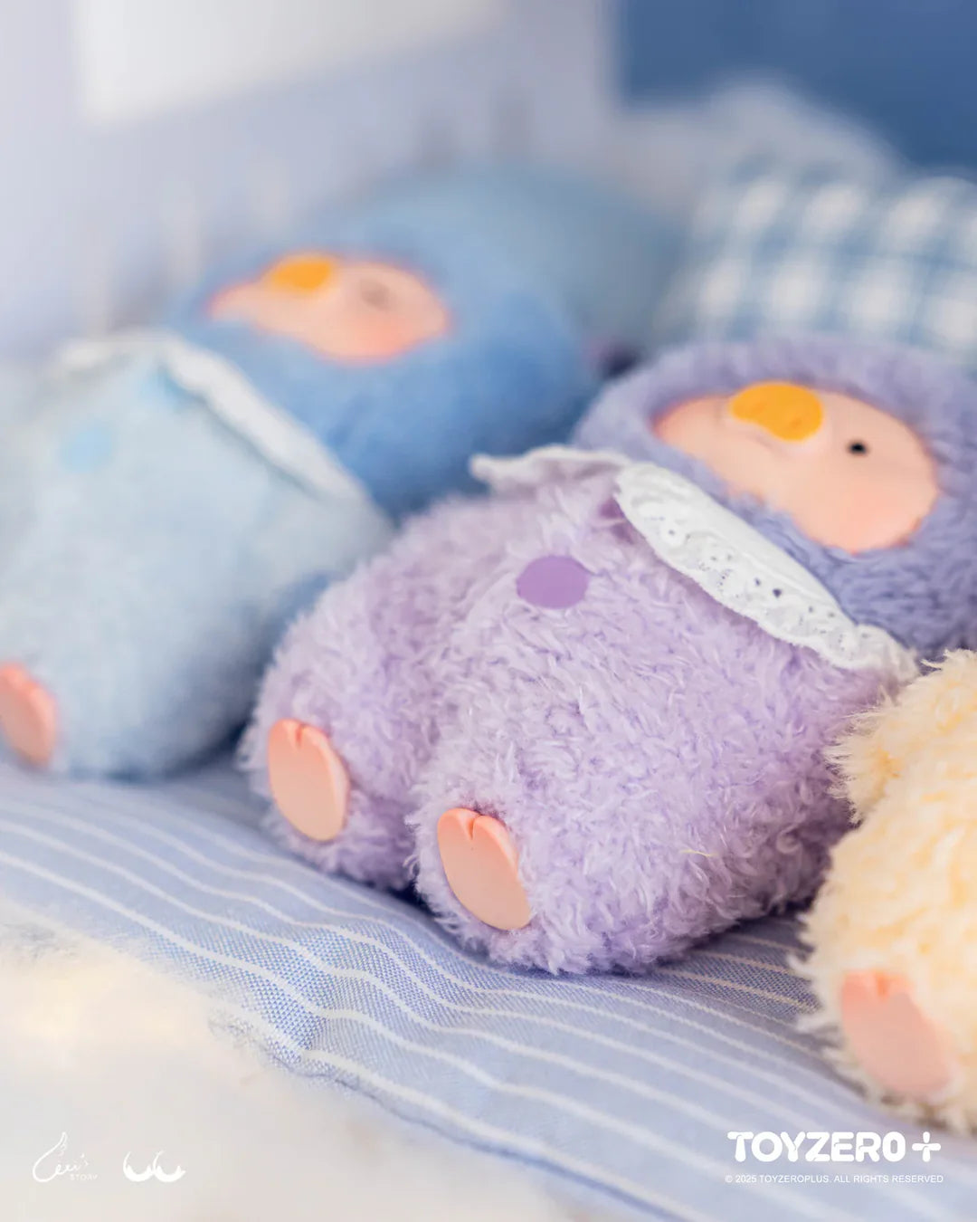 Close-up of pastel LuLu The Piggy Dreaming Wonderland plush characters resting on a bed