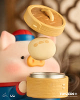 LuLu the Piggy dim sum chef holding a bamboo steamer.