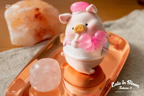 LuLu The Piggy Sakura 2 figure holding a pink sakura flower while sitting on a golden tray.
