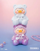 White and pearl pink LuLu The Piggy teddy bear mini figures stacked together on a pastel background