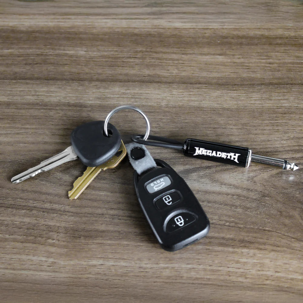 Megadeth guitar plug keychain with keys on wooden surface