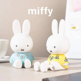 Blue and yellow floral Miffy phone stand figures displayed on a desktop
