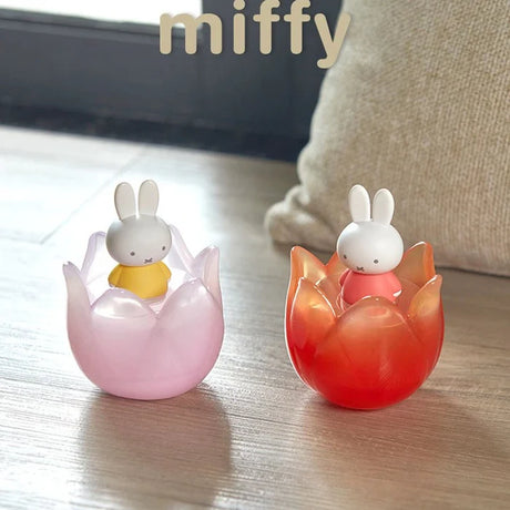 Pink and red tulip-themed Miffy collectible figures displayed on a wooden surface